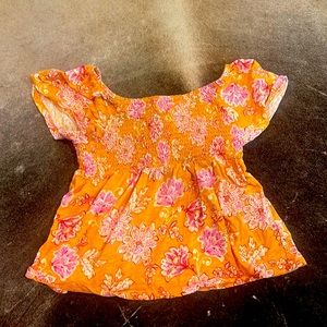 A mustard yellow top with white and magenta flowers